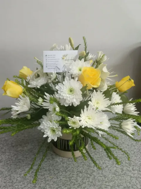 Yellow and white floral arrangement in a pot